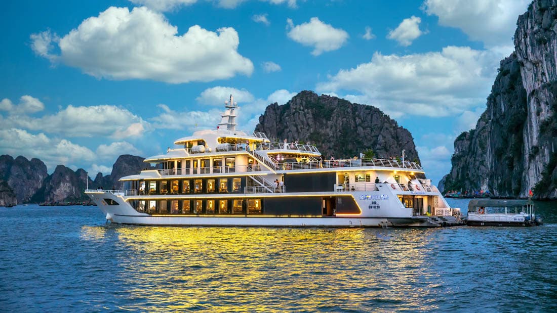 Une jonque traditionnelle en bois naviguant entre les îlots calcaires, baie d'Halong